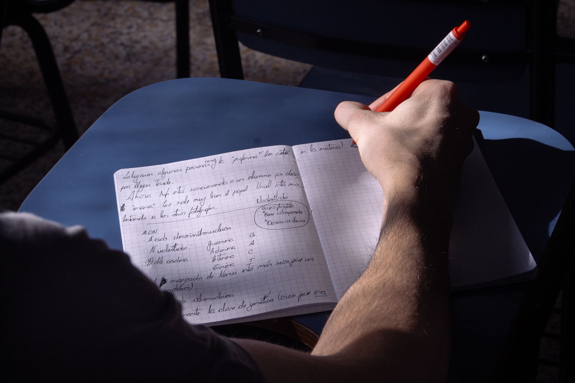 A person taking notes at a desk while researching a client writing project, natural light in the room.